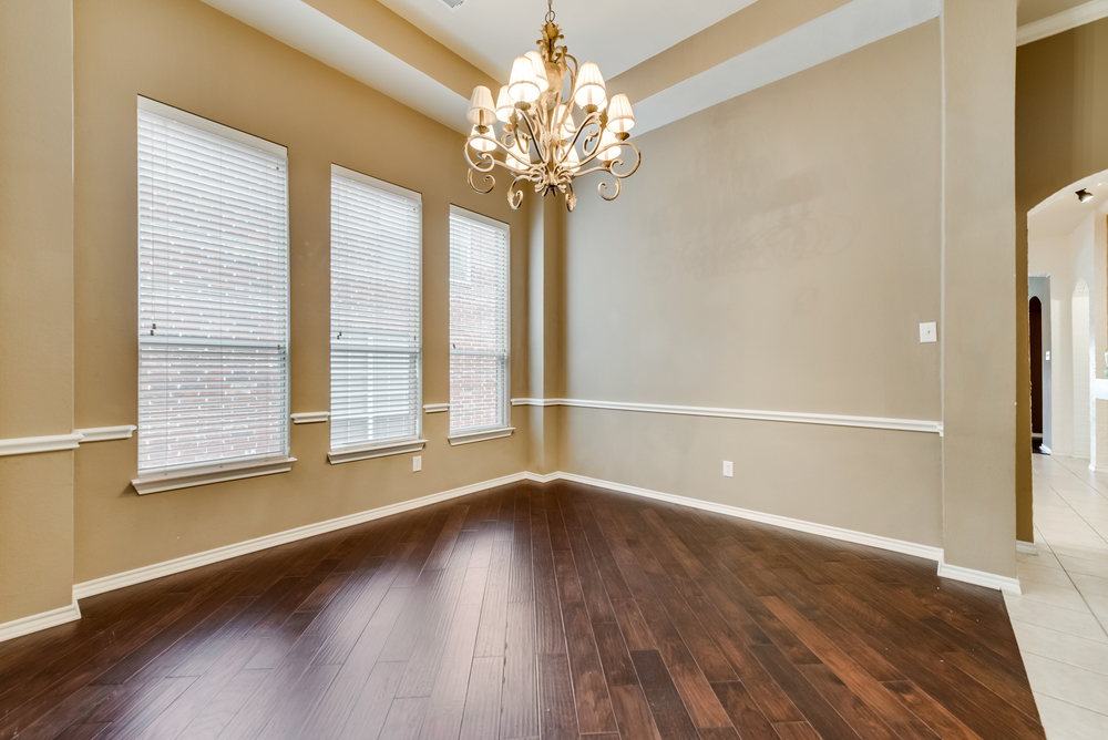    Formal dining offers hardwood floors tray ceiling and chic chandelier 