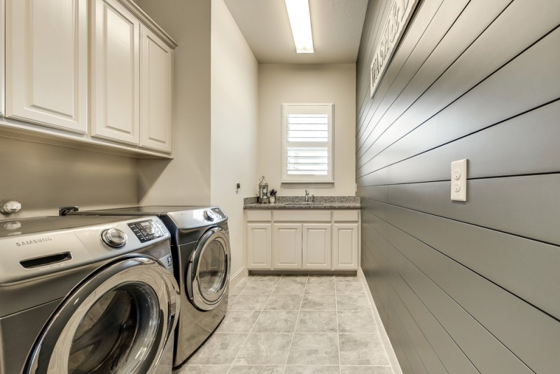    Spacious Utility Room with Sink Granite Countertop and Shiplap Accent Wall 