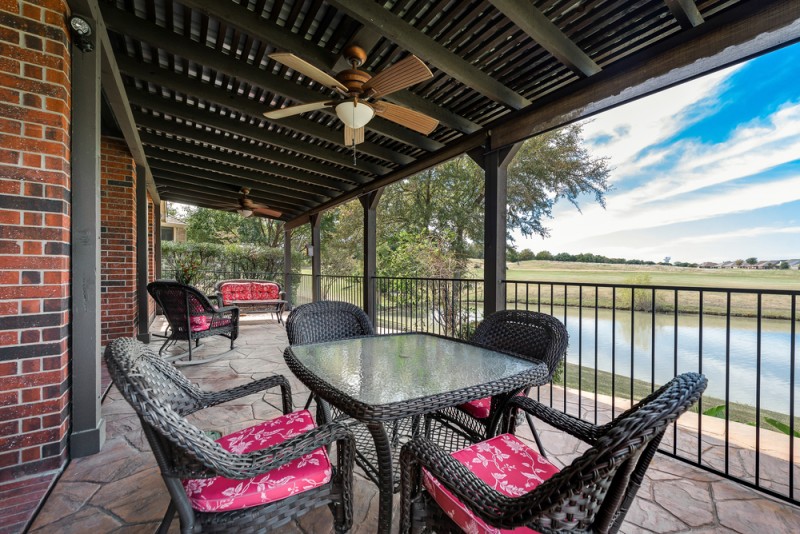    Extended Covered Stamped Concrete Patio with Fans and Shades Look out to Water and Golf Course Views 