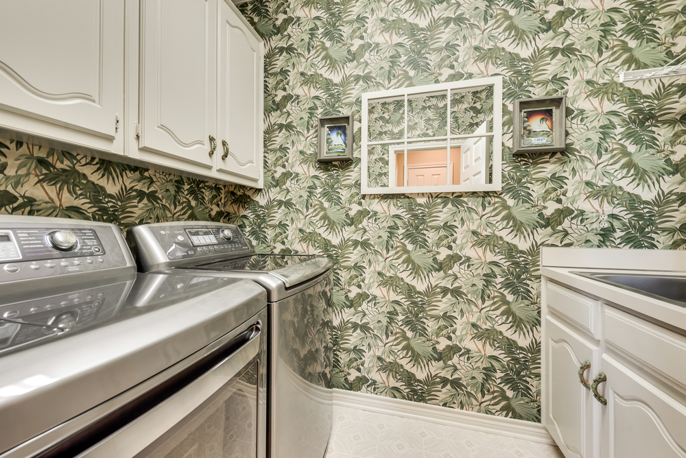    Utility Room has Built In White Cabinetry and Sink 