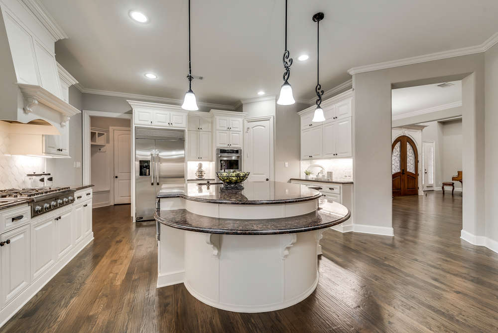    Gourmet Kitchen with Large Island Granite Counters and Sleek Glass Tile Backsplash 