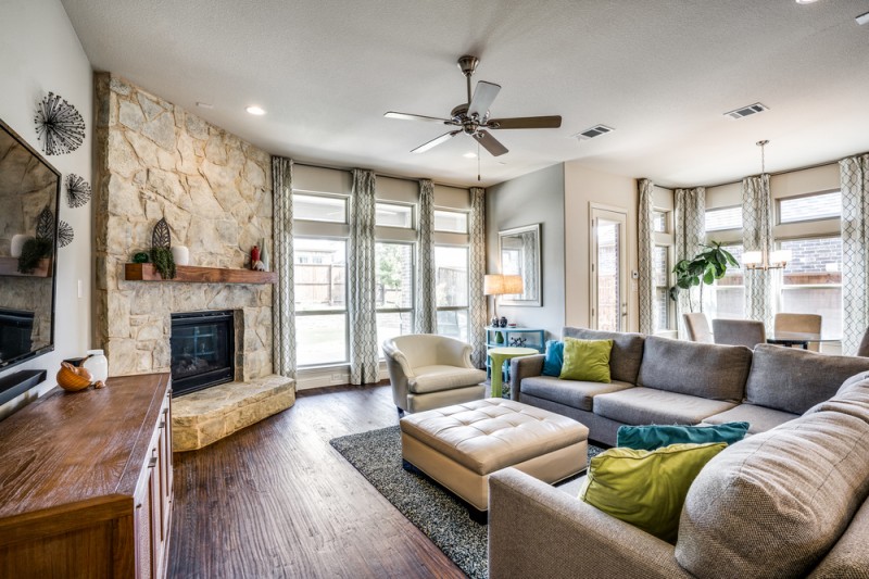    Family Room features Wall of Windows and Stone Gas Log Fireplace 